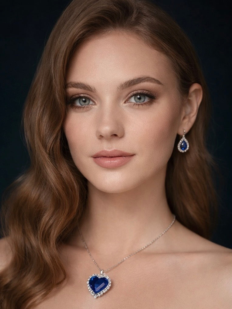 Woman wearing a blue heart-shaped necklace and earrings against a dark background by SommerSparkle